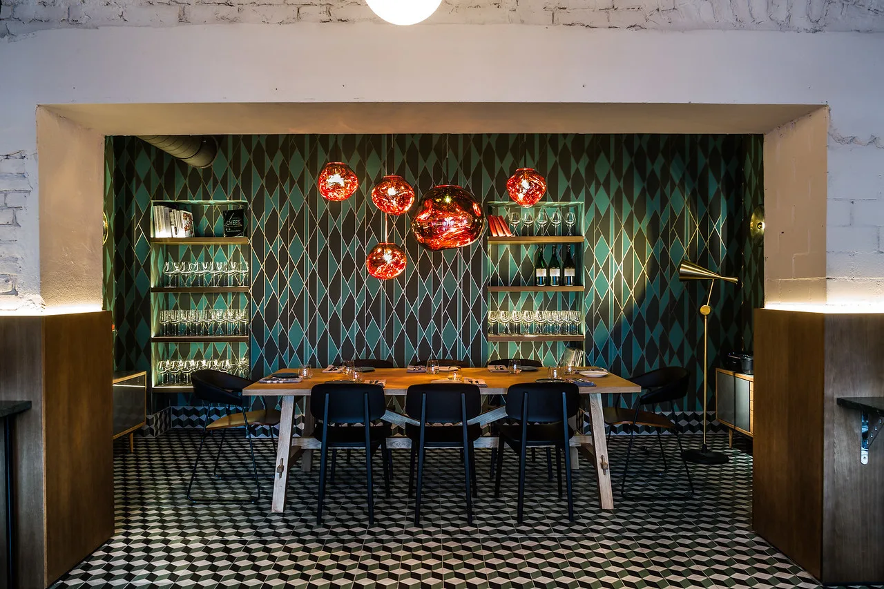 Blick durch den Torbogen in den Big-Tables-Party-Raum mit langer Tafel und gefliestem Boden