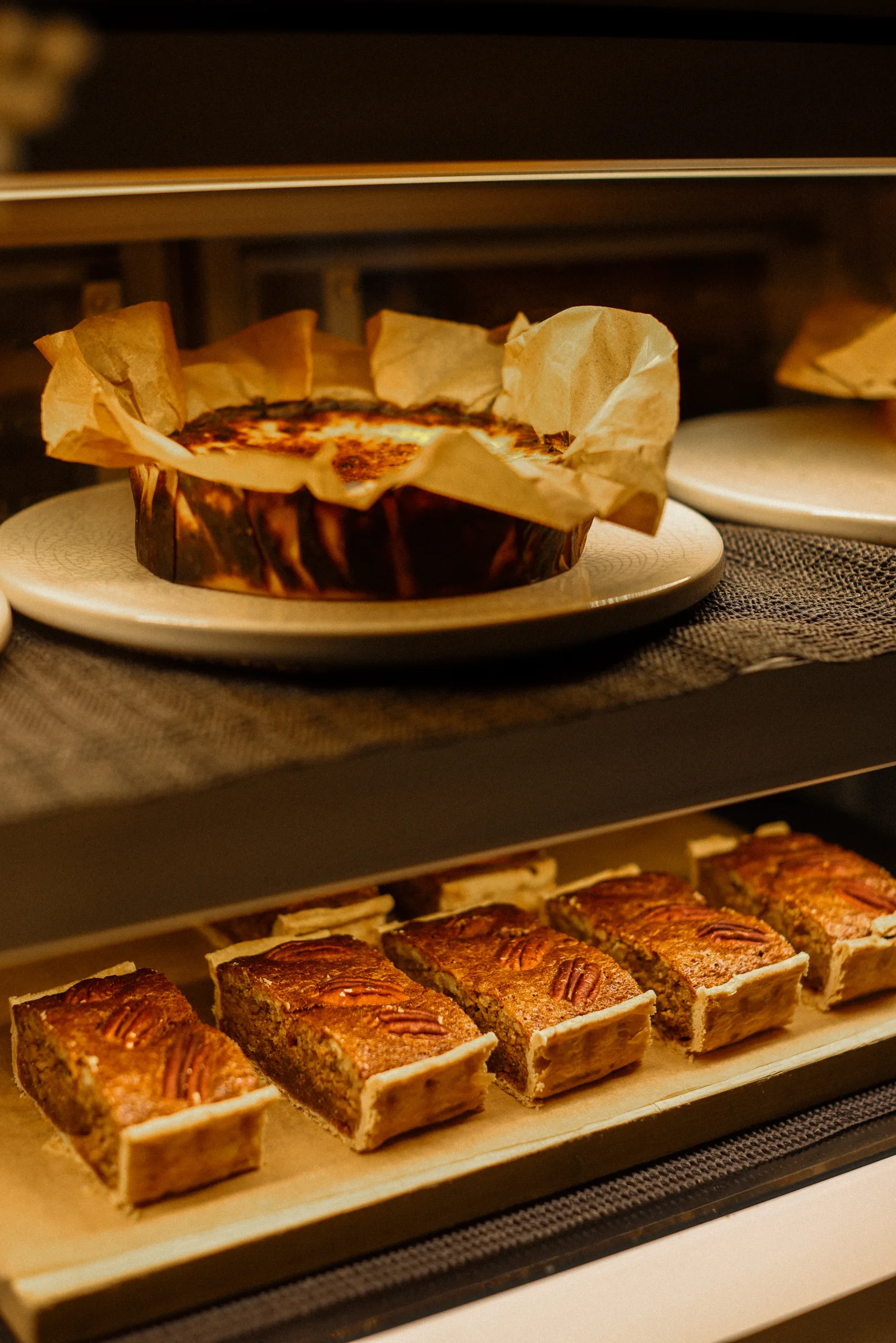 Warmer Pekannusskuchen mit einer Kugel Tonkabohnen-Eiscreme, Basque Cheesecake